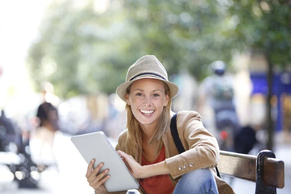 Mädchen sitzt mit Tablet auf Bank — Stockfoto