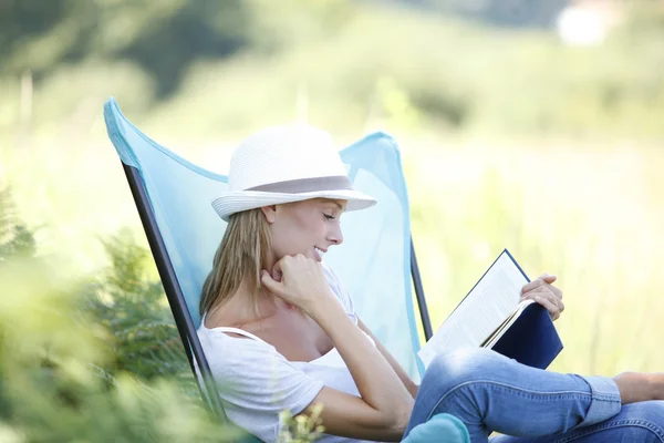 Mulher livro de leitura em cadeira ao ar livre — Fotografia de Stock