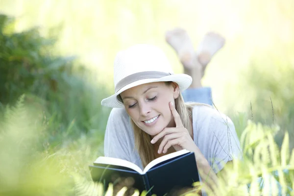 Frau legt Buch aus und liest — Stockfoto
