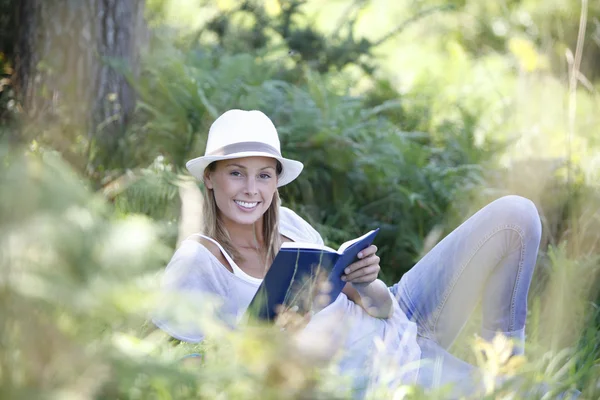 Mulher que coloca e leitura livro — Fotografia de Stock