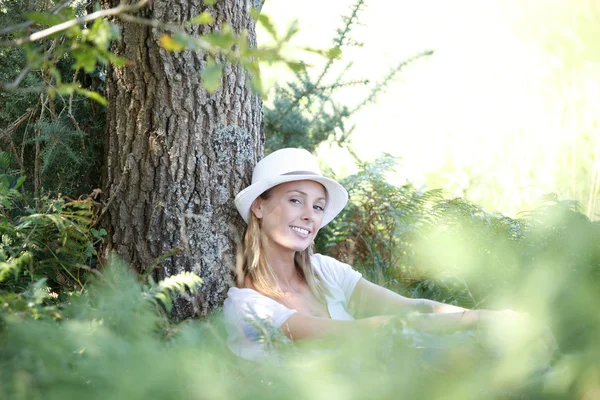 Žena s kloboukem relaxační v lese — Stock fotografie