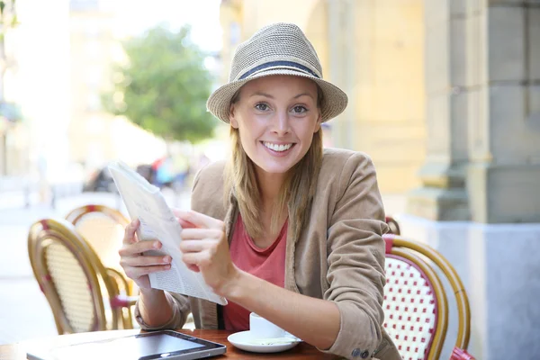 Girl in coffee shop reading newspaper — Stock Photo, Image