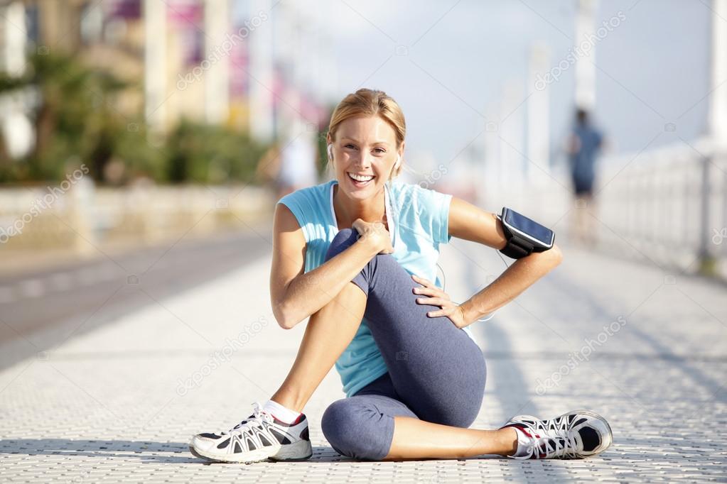 Jogger stretching after exercising in street