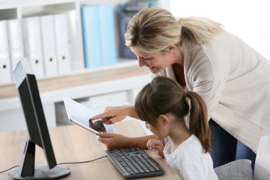 Öğretmen ile bilgisayar ve tablet kullanan kız