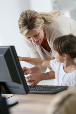 Öğretmen ile bilgisayar ve tablet kullanan kız
