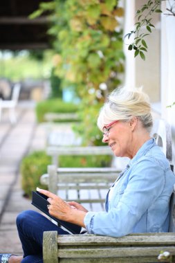 Üst düzey kadın bankta kitap okuma