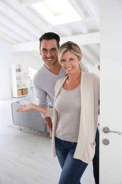 Mature couple standing at home clipart