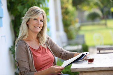 Kadın bahçede kitap okumak