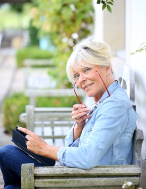 Üst düzey kadın bankta kitap okuma