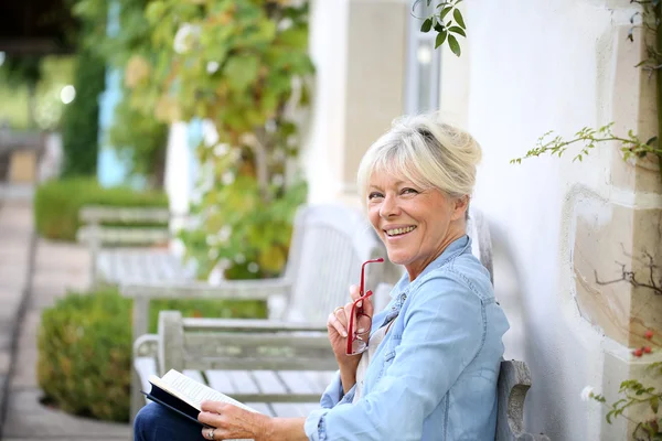 Senior livre de lecture femme sur banc — Photo