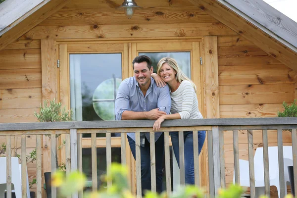 Casal em pé no terraço da cabine log — Fotografia de Stock