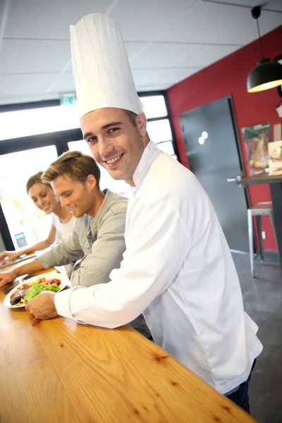 Chef sorrindo que serve clientes — Fotografia de Stock