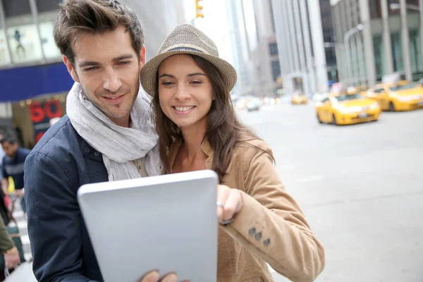 Ehepaar schaut sich Touristeninformation auf Tablet an — Stockfoto