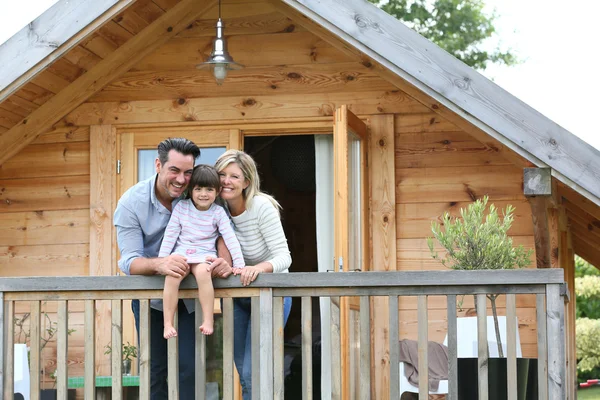 Family enjoying vacation in log cabin — Stock Photo, Image