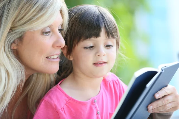 Femme avec fille apprenant à lire — Photo