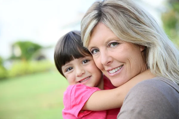 Frau umarmt kleines Mädchen in den Armen — Stockfoto