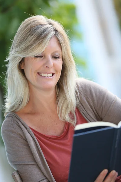 Mulher leitura livro no quintal — Fotografia de Stock