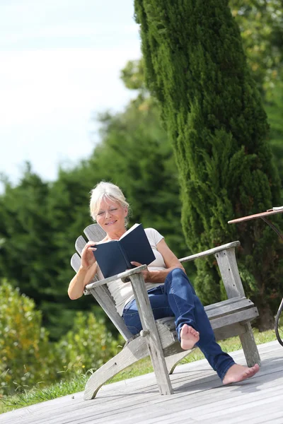 Woman reading book in backyard — Stock Photo, Image