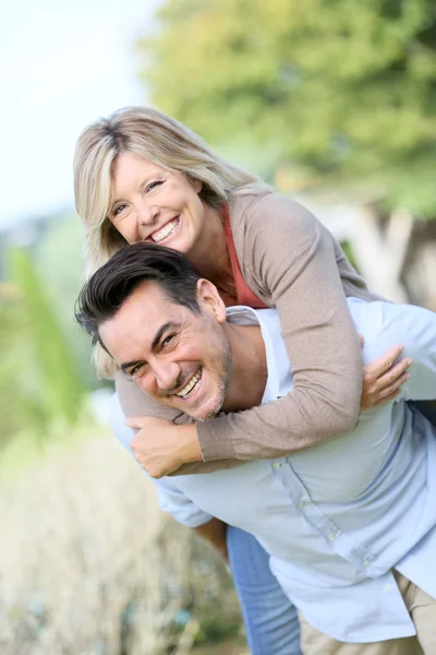 Man geven piggyback rit naar vrouw — Stockfoto