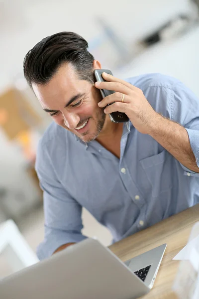 Businessman in office talking on phone — Stock Photo, Image