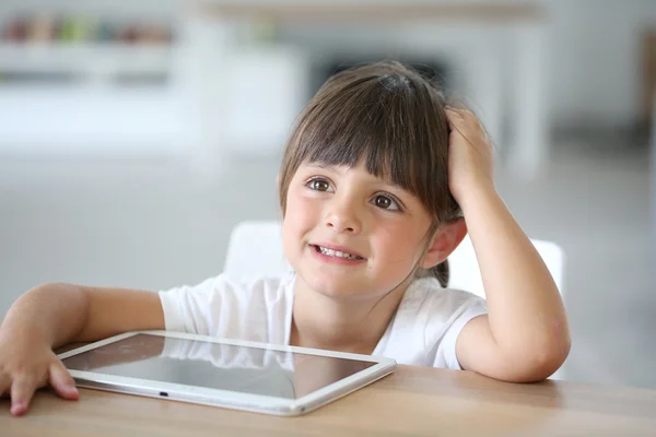 Четырехлетняя девочка играет с планшетом — стоковое фото