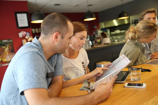 Students choosing dish from menu — Stock Photo, Image