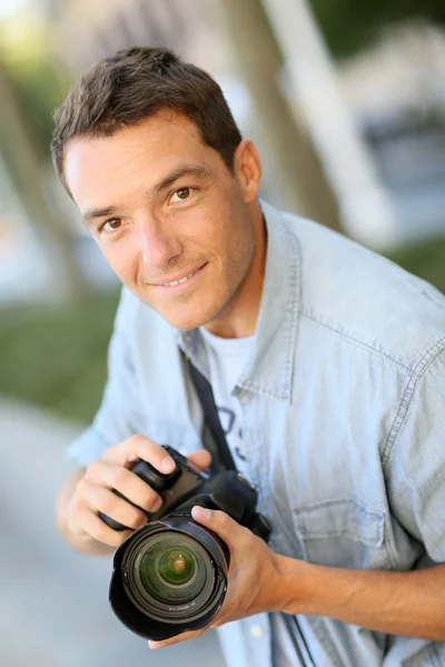 Fotógrafo usando câmera reflexa fora — Fotografia de Stock