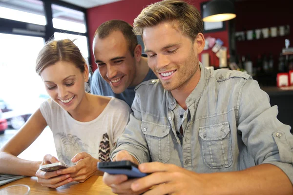 People in campus lounge connected on smartphone — Stock Photo, Image