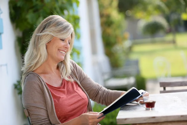 Frau liest Buch im Hinterhof — Stockfoto