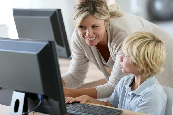 Lärare med skolpojke studerar på datorn — Stockfoto