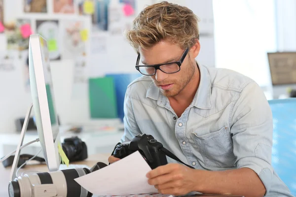 Joven reportero fotógrafo en oficina — Foto de Stock