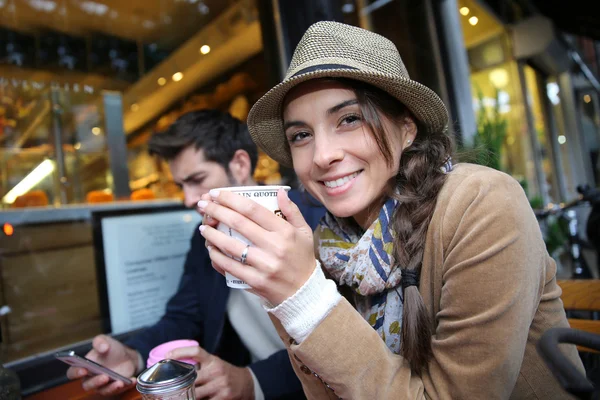 Woman at coffee shop holding cup — Stock Photo, Image