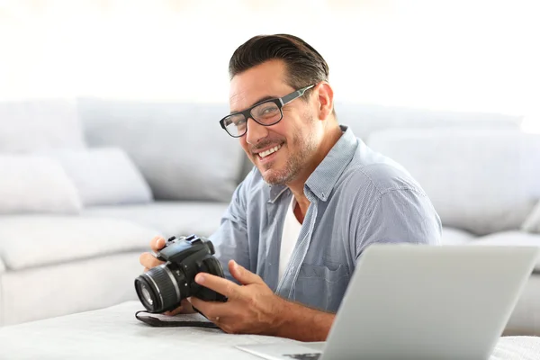 Hombre usando cámara réflex y portátil —  Fotos de Stock