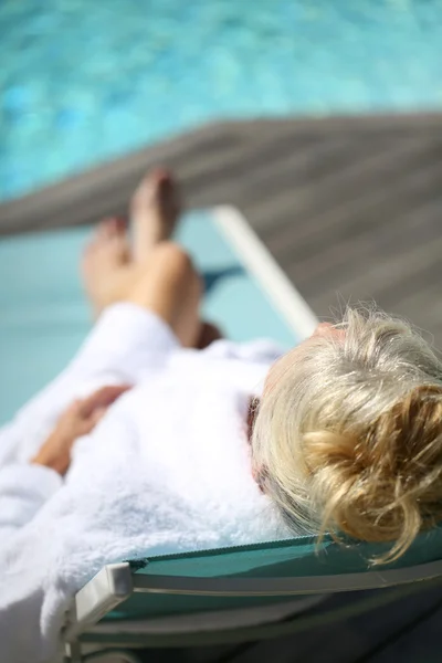 Senior mulher relaxante em cadeira longa — Fotografia de Stock