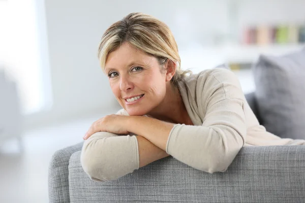 Mujer relaja en el sofá — Stockfoto