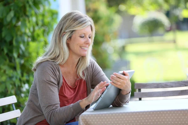 Femme assise en terrasse et utilisant une tablette — Photo