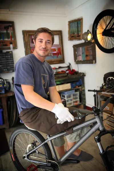 Smilng craftsman in bike workshop — Stock Photo, Image