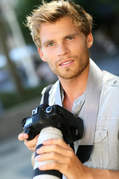 Yakışıklı fotoğrafçı holding kamera — Stok fotoğraf