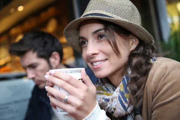 Kobieta w kawiarni trzymając kubek — Zdjęcie stockowe