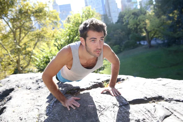 Athletic man in Park doing pushups — Stock Photo, Image