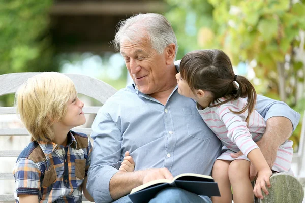 Man reading book with grandkids — Stock Photo, Image