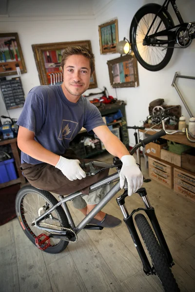 Smilng craftsman in bike workshop — Stock Photo, Image