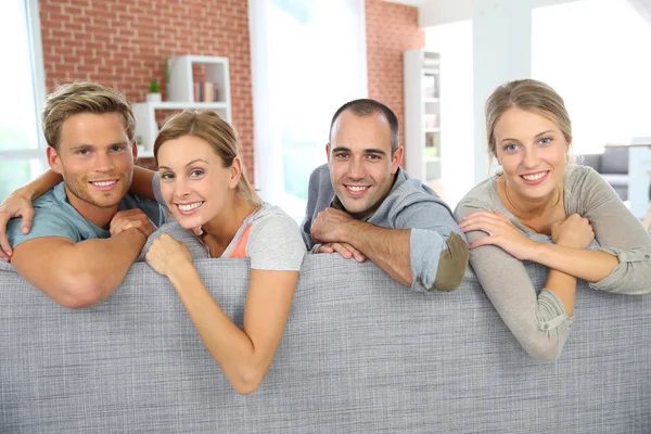 Cheerful roommates sitting in sofa — Stock Photo, Image