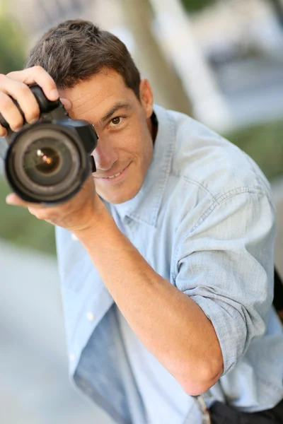 Fotógrafo usando câmera reflexa fora — Fotografia de Stock