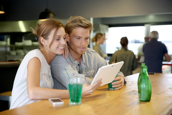 Friends in bar websurfing on tablet — Stock Photo, Image