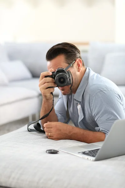 Člověk s použitím digitálního fotoaparátu a laptop — Stock fotografie