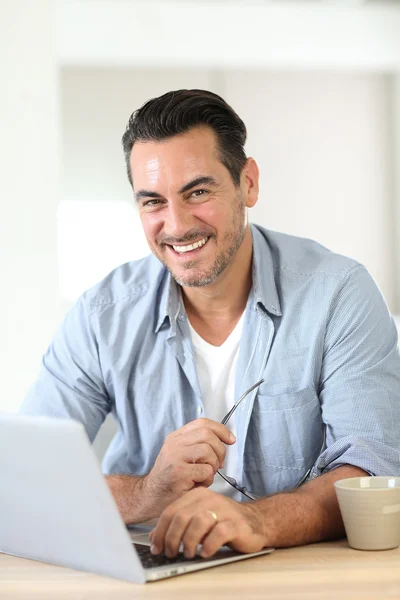 Muž pracující doma s laptopem — Stock fotografie