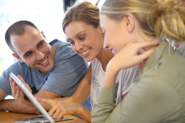 Friends in campus lounge websurfing with tablet — Stock Photo, Image