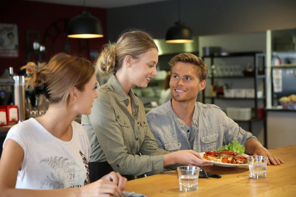 Kellnerin bedient Studenten im Restaurant — Stockfoto