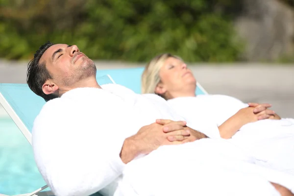 Casal relaxante à beira da piscina — Fotografia de Stock